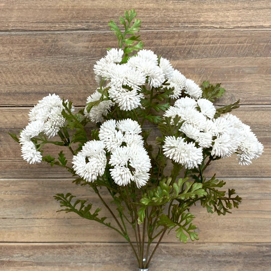 Bouquet of white flowers with green leaves on a wooden background